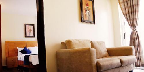 a living room with a chair and a bed at Swiss International The Vistana Lekki Lagos in Ikota