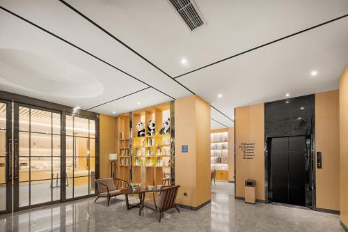 a lobby with a table and chairs in a building at Atour Hotel -Du Fu Thatched Cottage in Chengdu