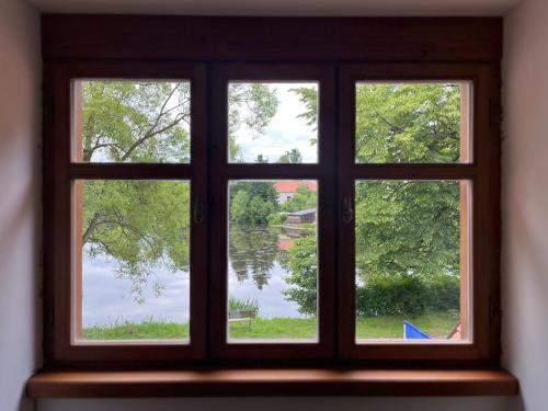a window with a view of a lake seen through it at Apartmany Klub Jablíčko in Humpolec