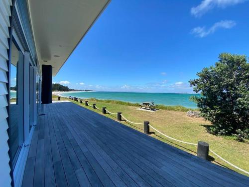 a porch of a house with a view of the ocean at Rangi Beachfront -Luxury Beachfront Bach in Karikari Peninsula