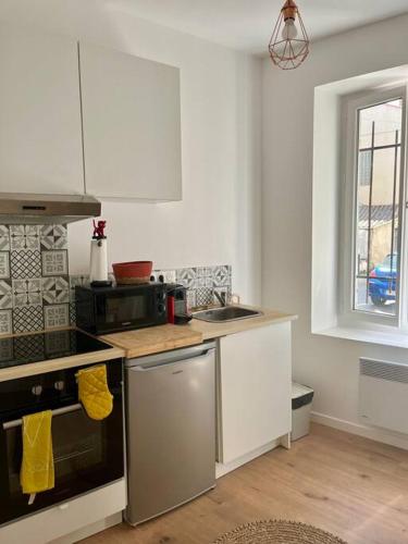 une cuisine avec un évier et une cuisinière four supérieur dans l'établissement Appartement hyper centre climatisé, à Salon-de-Provence