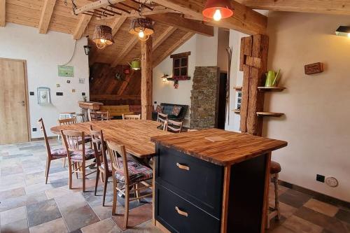 une cuisine et une salle à manger avec une table et des chaises en bois dans l'établissement Le Grenier de Jules et Marguerite, à Liézey