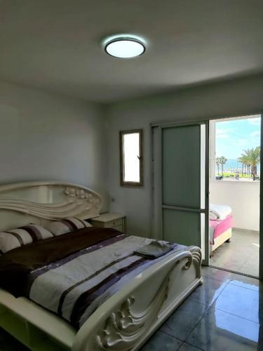 a bedroom with a bed and a sliding glass door at Apartments by the beach 60-6 in Qiryat H̱ayyim