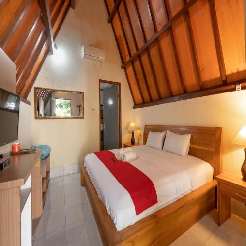 a bedroom with a large bed and a television at RedDoorz at Ocean 2 Gili Trawangan in Gili Trawangan