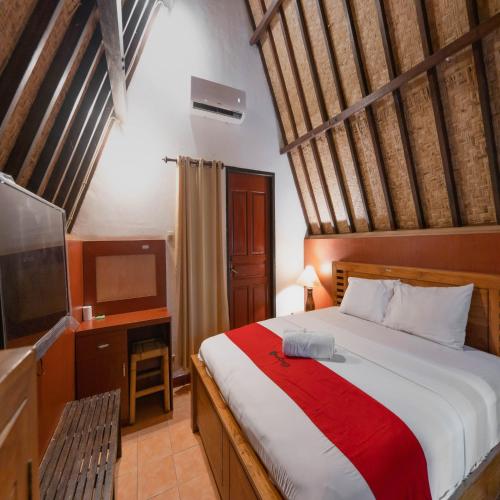 a bedroom with a large bed and a television at RedDoorz at Ocean 2 Gili Trawangan in Gili Trawangan
