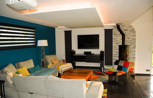 a living room with two couches and a tv at Villa du Val d'Usiers in Bians-les-Usiers
