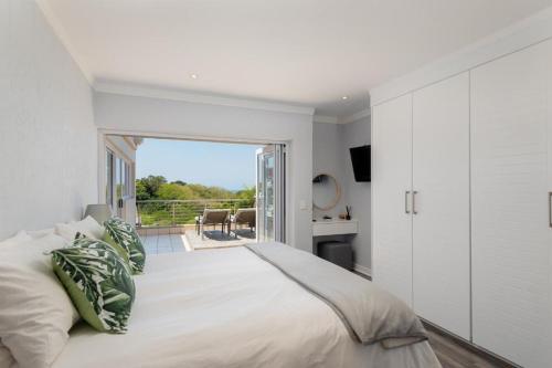 a bedroom with a large bed and a balcony at Sea View 3-Bed Apartment in Simbithi Eco Estate in Shakaʼs Rock