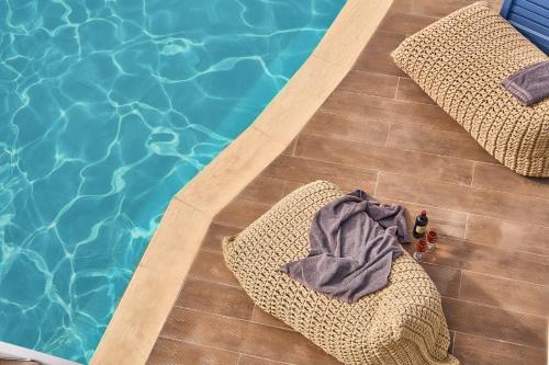 an overhead view of a swimming pool with towels and chairs at Arte & Mare Elia Luxury Suites and Villas in Elia Beach