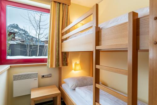 a bedroom with bunk beds with a window at Hotel Tyrol am Haldensee in Haldensee