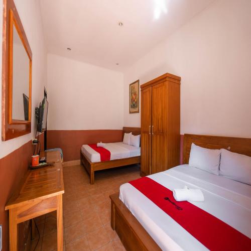 a hotel room with a bed and a desk at RedDoorz at Ocean 2 Gili Trawangan in Gili Trawangan