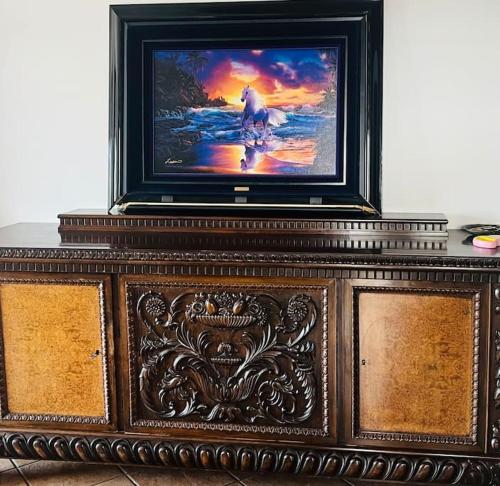 a tv sitting on top of a wooden stand at Whole flat 95 sq m by the sea close to airport with garden in Agios Spyridon