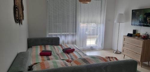 a bedroom with a bed and a dresser and a window at Summer Park Residence Peljesac in Orebić