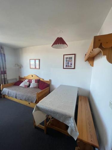 une chambre avec un lit et une table dedans dans l'établissement appartement Risoul 1850, à Risoul