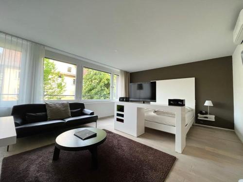 a living room with a couch and a tv at City Apartments in Zug