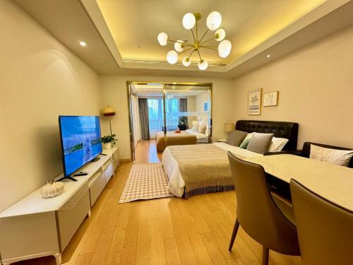 a bedroom with a bed and a desk with a television at Shanghai Lerongju Boutique Apartment Metro Line 8 20meter in Shanghai