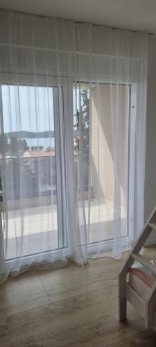 a room with two large windows with white curtains at Summer Park Residence Peljesac in Orebić