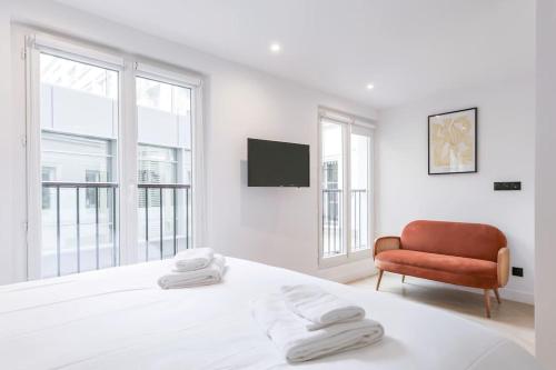une chambre blanche avec un lit et une chaise dans l'établissement Urban Retreat Brand-New Duplex 2-Bedroom, à Paris