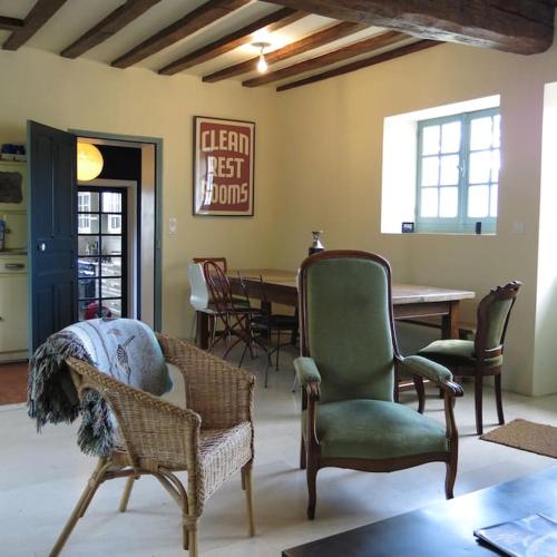 - un salon avec des chaises et une table à manger dans l'établissement Maison de charme sur le canal de Bourgogne et près de Chablis, à Ancy-le-Libre