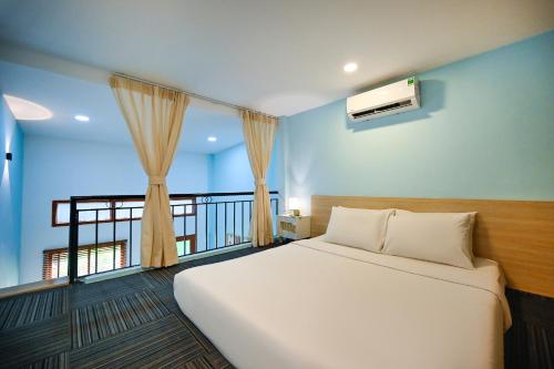 胡志明市Jade Garden by La Doma Express的一间带白色床的卧室和一个阳台