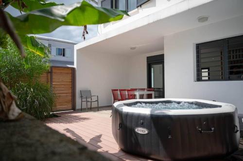 a large hot tub sitting on a patio at Ecumes Sauvages - DODOTERLA in Manapany-les Bains