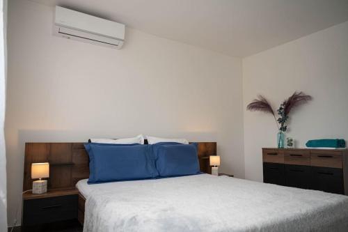 a bedroom with a large bed with blue pillows at Ecumes Sauvages - DODOTERLA in Manapany-les Bains