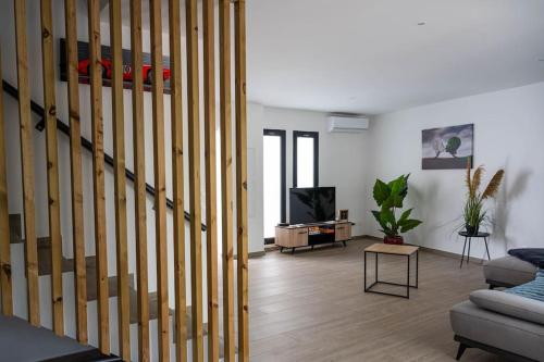 a living room with a couch and a tv at Ecumes Sauvages - DODOTERLA in Manapany-les Bains