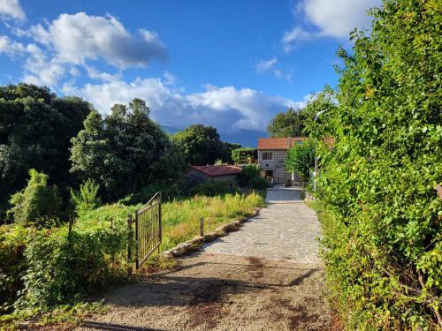 a dirt road leading to a house in a field at Chez Paulette - meublé de tourisme classé 3 étoiles in Zonza
