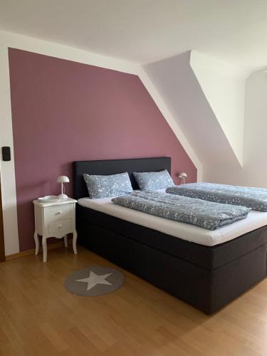 a bedroom with a large bed and a purple wall at Wiedenbrück Zentrum schöne Wohnung mit Balkon-8- in Rheda-Wiedenbrück