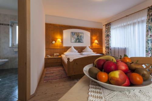Hotel Jägerhof في سان ليوناردو إن باسيريا: وعاء من الفواكه على طاولة في غرفة الفندق
