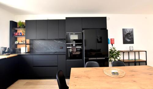a kitchen with a black refrigerator and a table at Spacious 3BR Penthouse with Large Front Terrace - Stone BBQ & Sun Loungers in Taʼ Bullara