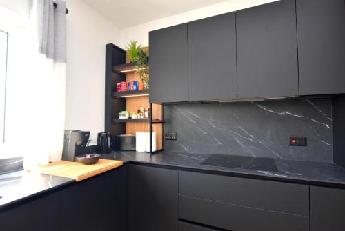 a kitchen with black cabinets and a black counter top at Spacious 3BR Penthouse with Large Front Terrace - Stone BBQ & Sun Loungers in Taʼ Bullara