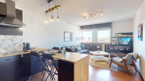 une cuisine et un salon avec une table et un canapé dans l'établissement Meublé du Faubourg - Centre/Gare, à Strasbourg