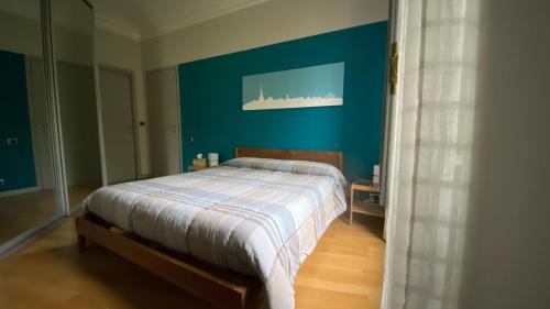 a bedroom with a bed with a blue wall at Casa Dante in Turin