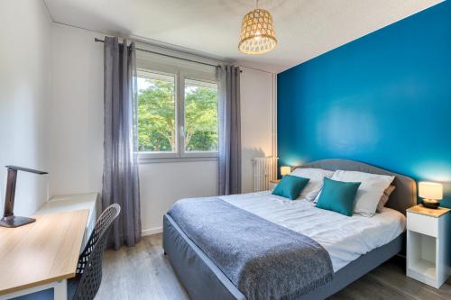 - une chambre bleue avec un lit et un bureau dans l'établissement Appartement tout confort - Parking privé gratuit, à Rouen