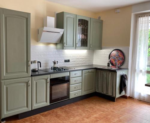 a kitchen with green cabinets and a sink at Casa Finestre Bianche in Canelli