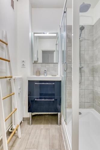 une salle de bain avec un lavabo bleu et une douche dans l'établissement Appartement tout confort - Parking privé gratuit, à Rouen