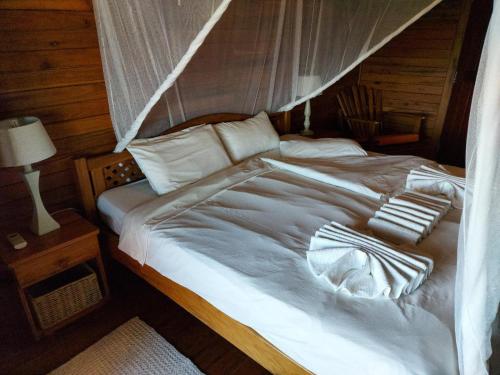 a bedroom with a white bed with a canopy at Chicuanga in Chizavane