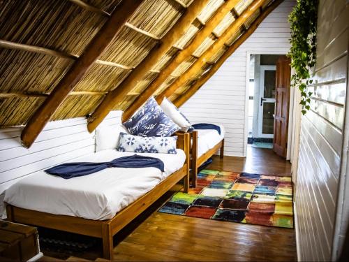 a attic bedroom with two beds and a rug at Chicuanga in Chizavane