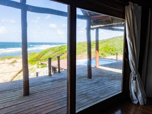 a room with a view of the beach from a window at Chicuanga in Chizavane