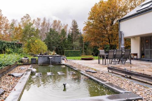 a backyard with a pond with ducks in it at La chauve souris Home in Houffalize