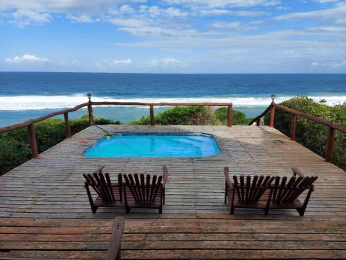 a deck with two chairs and a swimming pool on the beach at Chicuanga in Chizavane