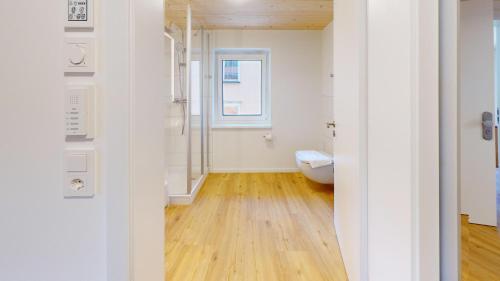 a bathroom with a toilet and a window at HEIMATEL - Ferienhaus Prinz-Lui in Scheidegg