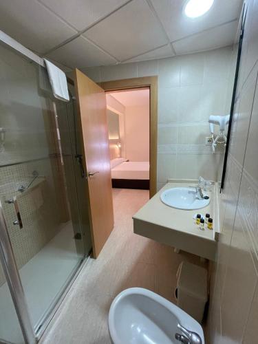 a bathroom with a sink and a shower and a toilet at Hotel Marconi in Benidorm