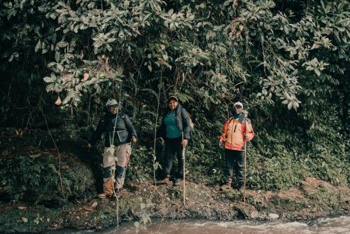 three people are standing in front of a tree at Eliper Hotel 