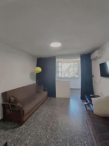 a living room with a couch and a television at Comfortable flat near Haifa 22 in Qiryat H̱ayyim