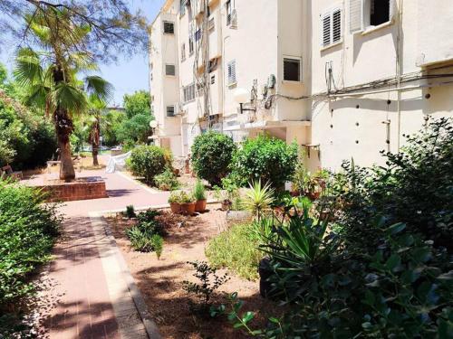 a garden in front of a building with plants at Comfortable flat near Haifa 22 in Qiryat H̱ayyim