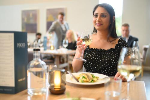 a woman sitting at a table with a glass of wine at Edgbaston Park Hotel Birmingham in Birmingham