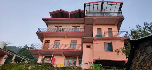 a tall pink building with balconies on it at Sejal Homestay in Shimla
