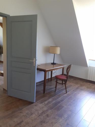 Cette chambre comprend un bureau, une porte et une chaise. dans l'établissement Chambre à la campagne, à Saint-Hilaire-des-Landes