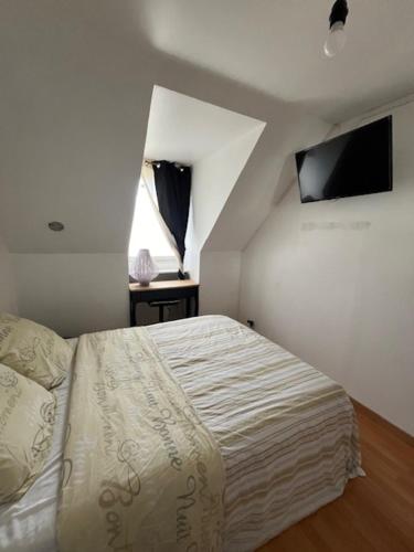 une chambre avec un lit dans une pièce blanche dans l'établissement Chambre Guestroom, à Nandy